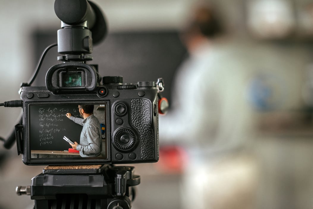 Camera showing a teacher explaining maths. 